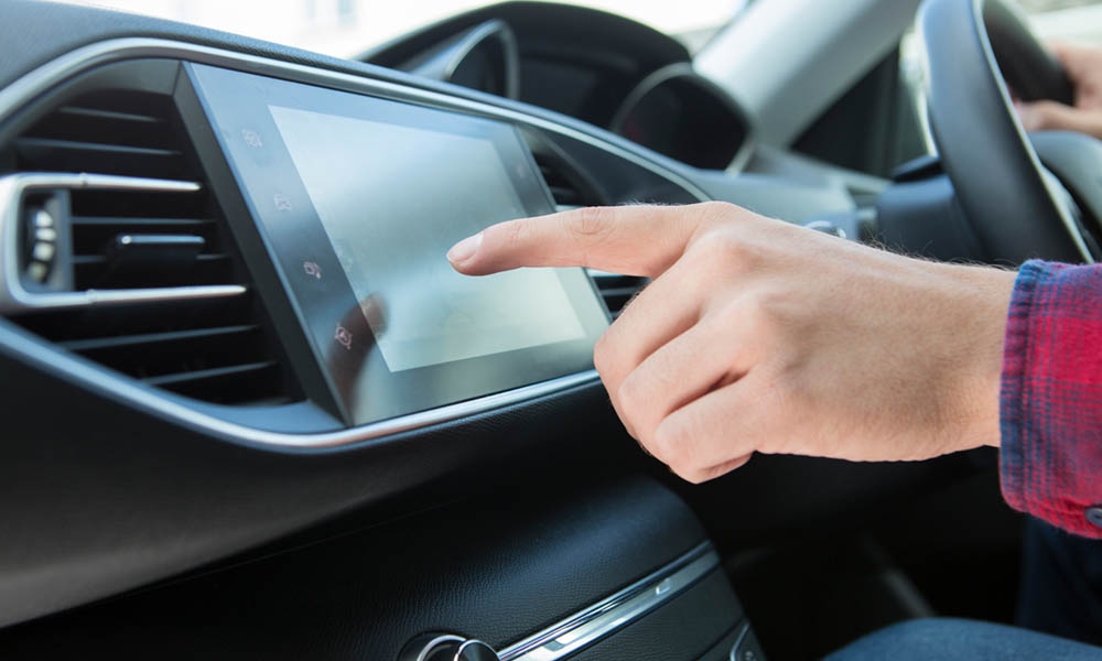Close Up Of Driver Using Touchscreen In Car