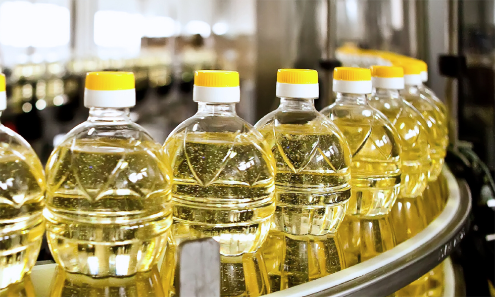 Conveyor with several bottles containing corn oil produced using Momentive’s antifoams, which can deliver effective foam control in highly alkaline, highly acidic, and neutral systems.