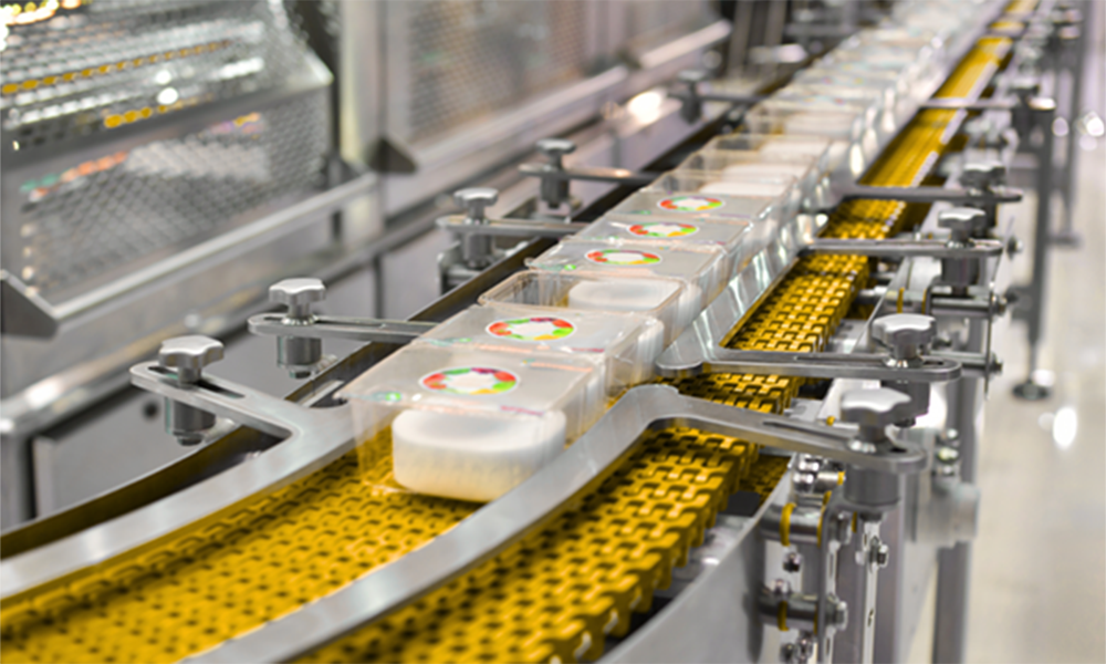 Food packaging conveyor line with sealed containers, representing Momentive’s food-grade mold release agents for clean demolding and efficient production.