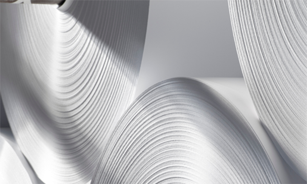 Close-up of large white paper rolls, representing Momentive’s SAG™ 2226 antifoam concentrate for improved foam control in Kraft chemical pulping applications.