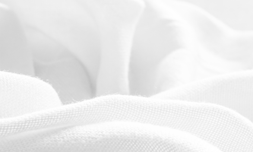 Close-up of a white fabric treated with hydrophilic textile finishing products to elevate water absorption properties and superior softness. 