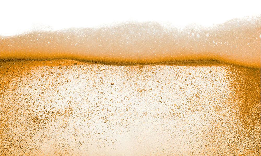 Close-up of foam layer on liquid surface, representing Momentive’s foam control solutions including defoamers, antifoam agents, and de-aerating additives for industrial processes.