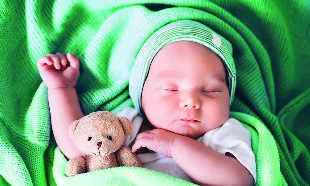 목욕 후 녹색 수건에 싸인 아기