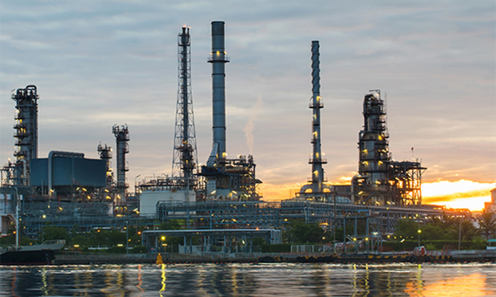 Refinaria de petróleo com o pôr do sol ao fundo