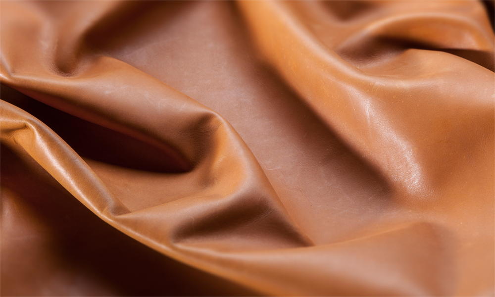 Close-up de uma superfície lisa de couro marrom, tratada com os surfactantes de silicone da Momentive para melhorar as superfícies do couro e garantir uma aparência consistente.