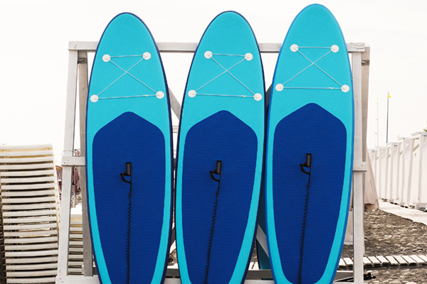 Set of stand-up paddleboard for SUP surfing in surf station on beach